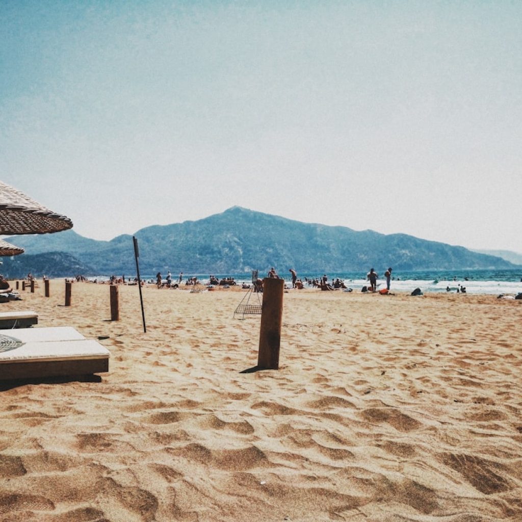 a sandy beach with umbrellas and people on it