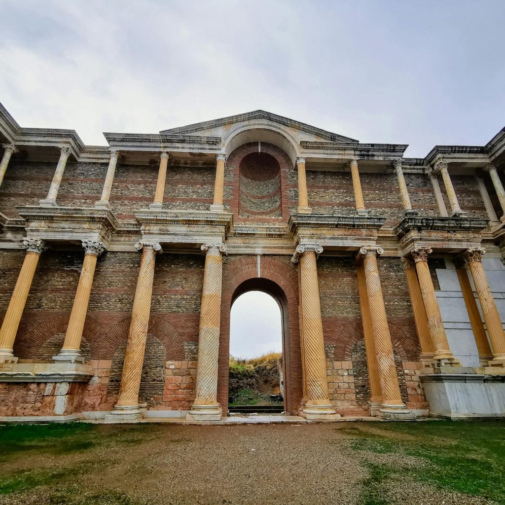 Stunning ancient Roman temple facade with brick and columns under a blue sky.