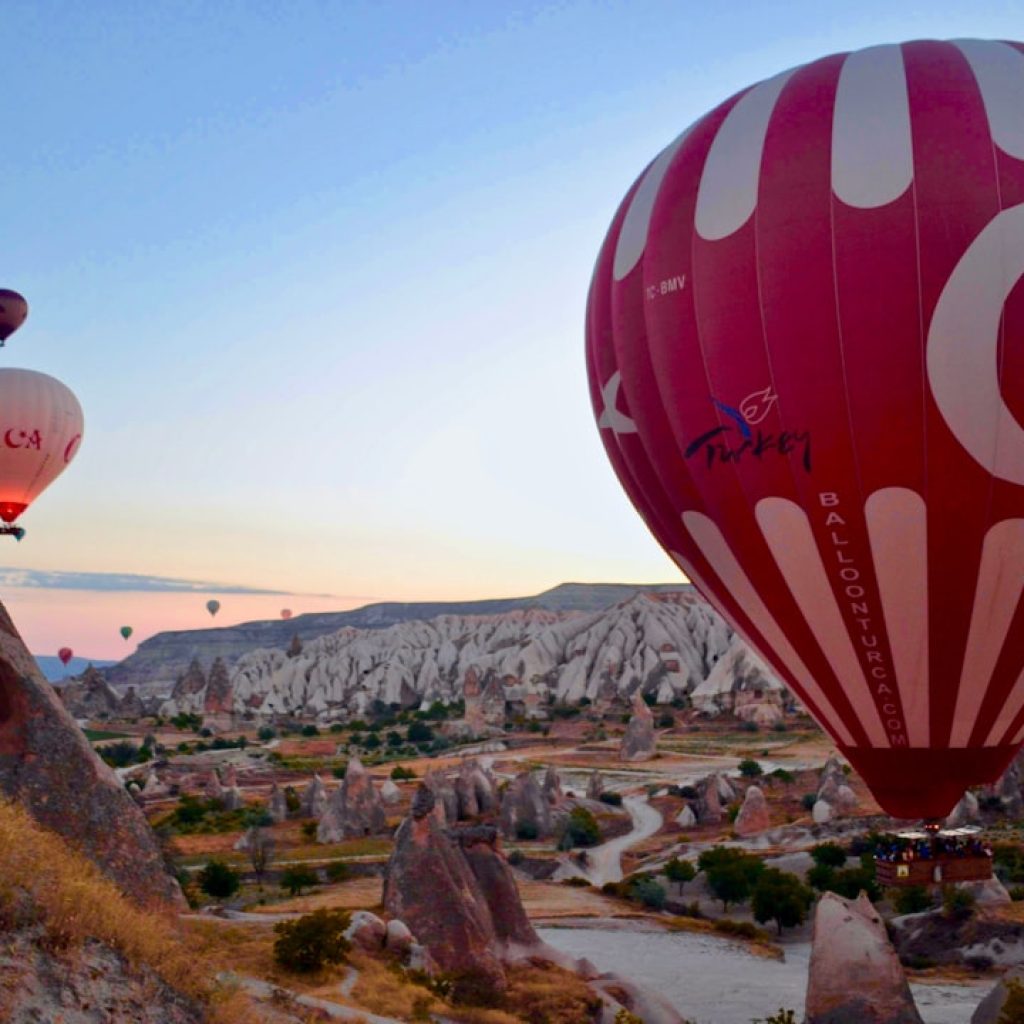 hot air balloons above mountains
