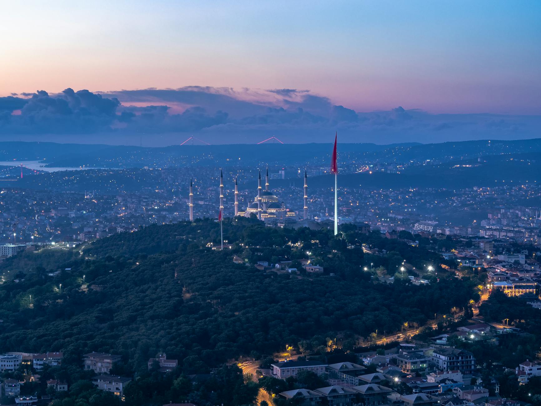 Stunning aerial view of Istanbul at twilight, featuring the Camlica Mosque illuminated against the city skyline.