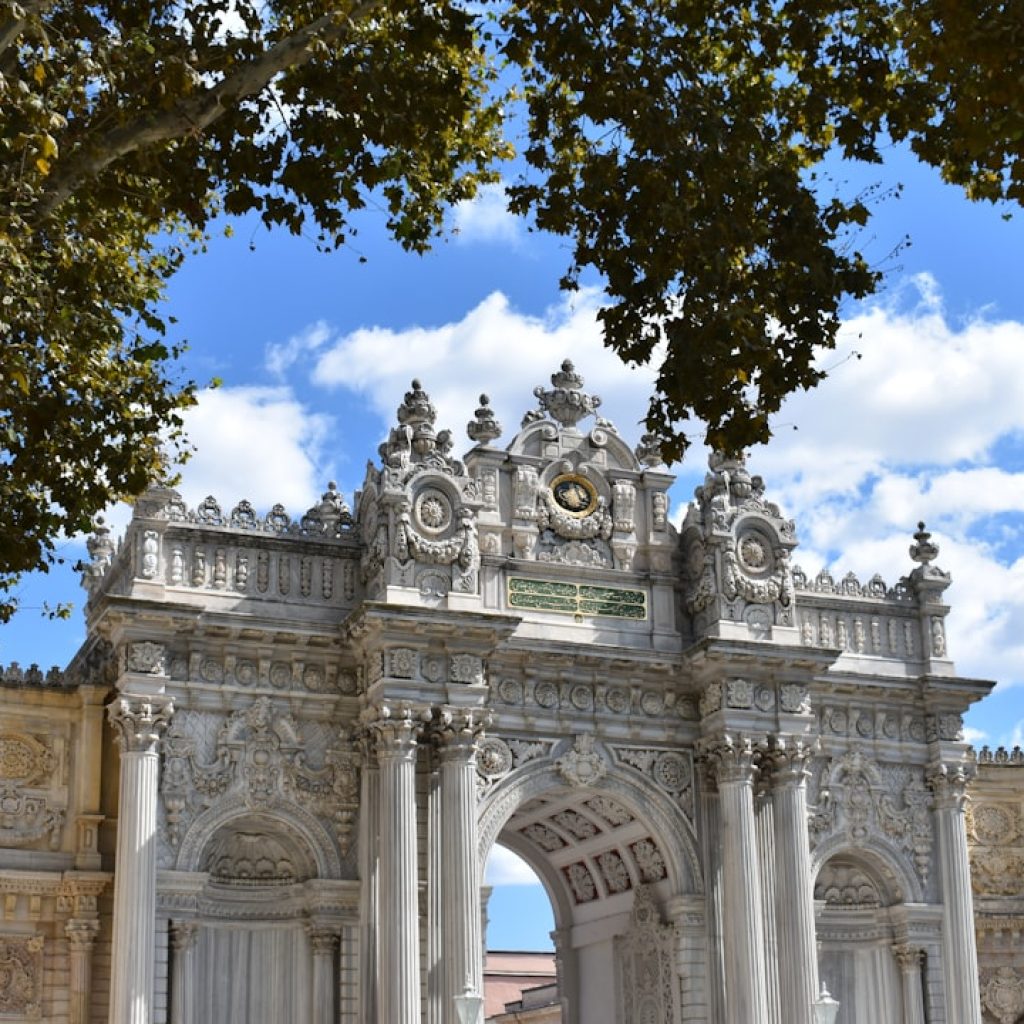 a large white arch with a clock on top of it