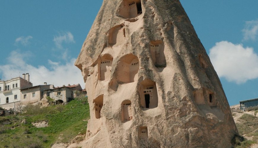 Captivating view of a fairy chimney rock formation against a blue sky in Cappadocia, Türkiye