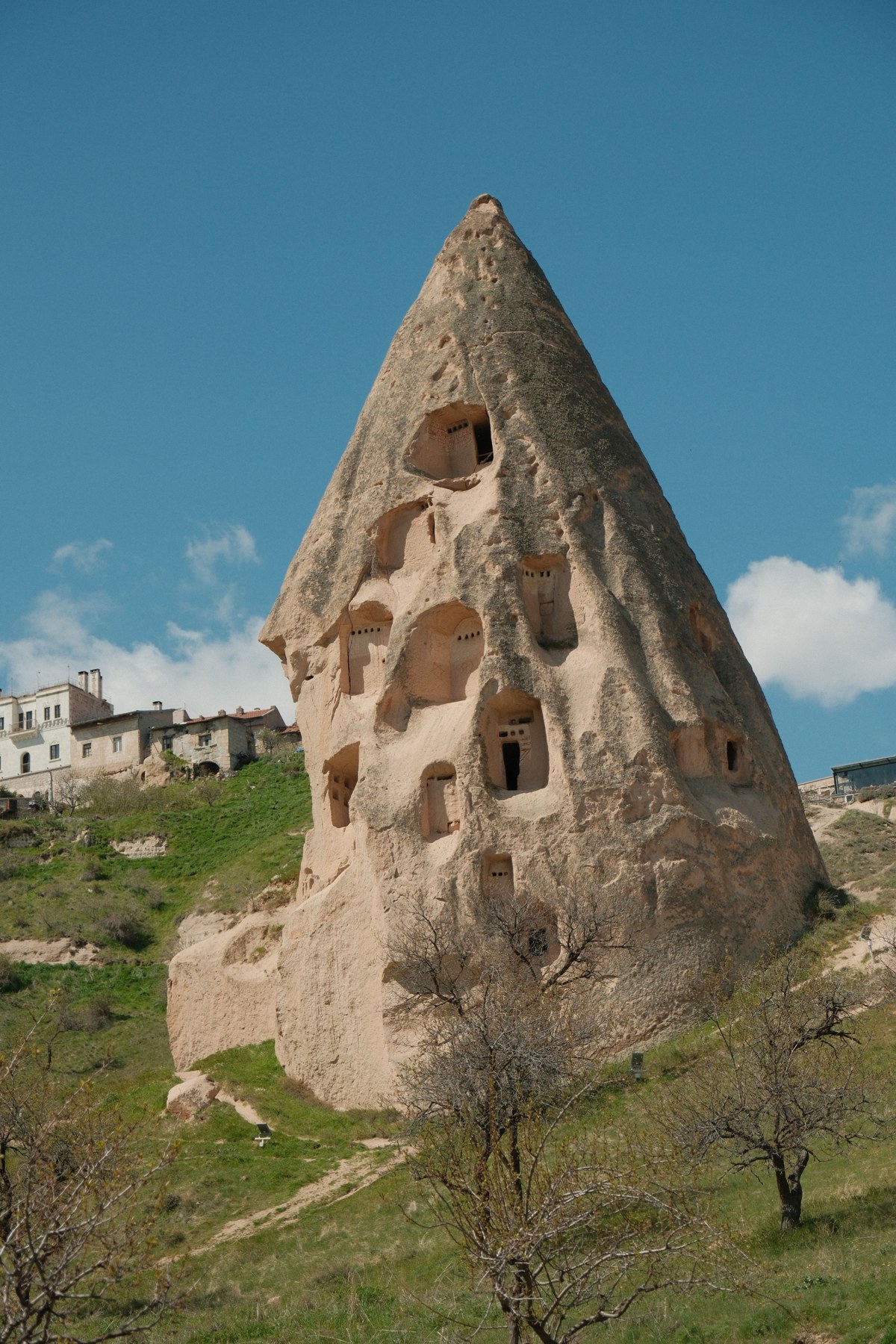 Captivating view of a fairy chimney rock formation against a blue sky in Cappadocia, Türkiye
