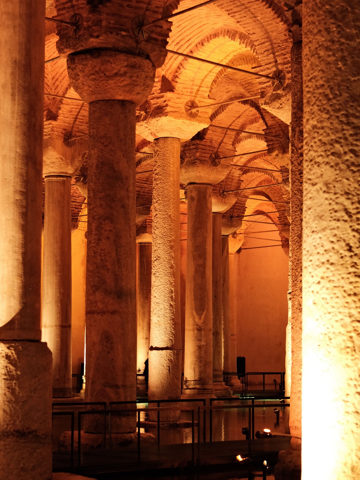 Illuminated ancient stone columns inside an historic underground cistern, creating a mysterious ambiance